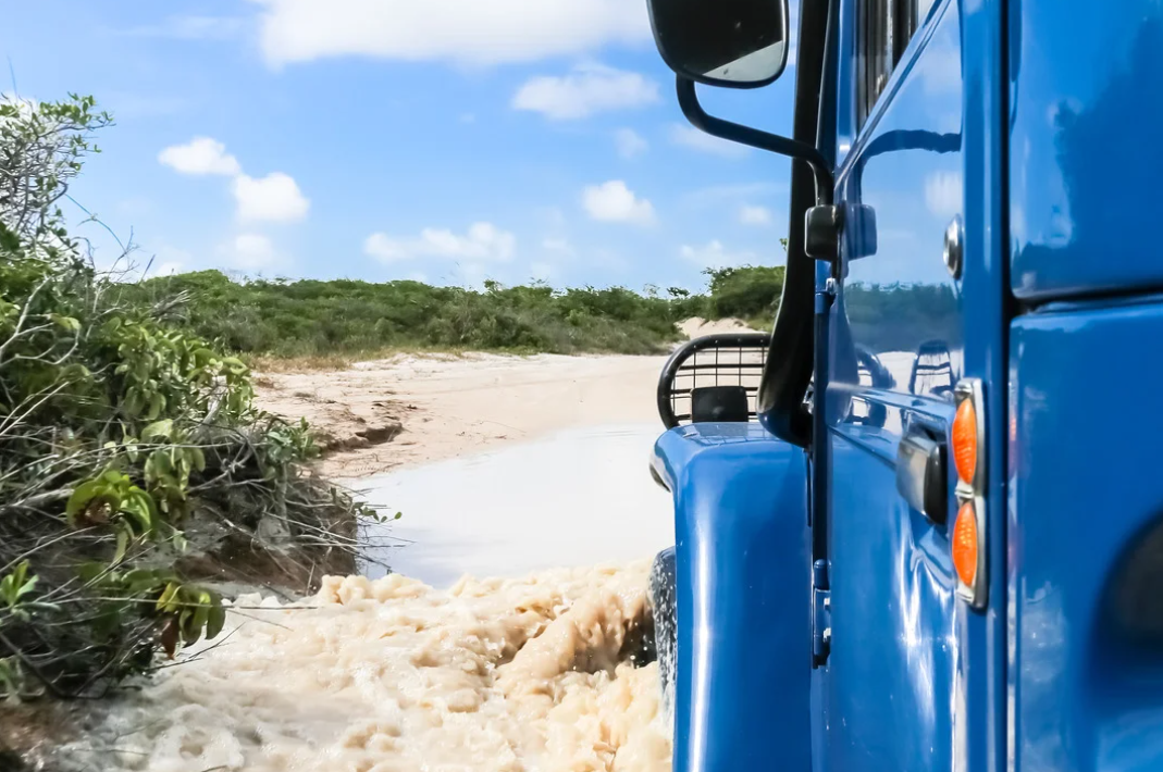 Veículo 4x4 passando por poça d’água na trilha de Jeri.